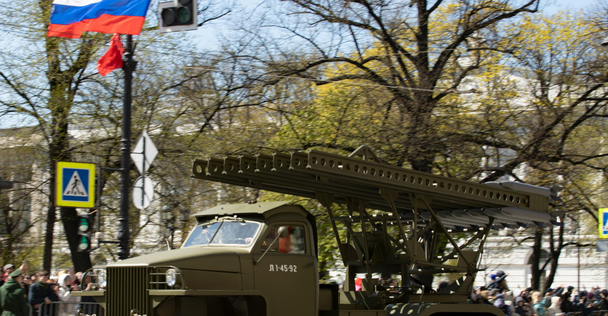 A russian military vehicle parades in the street.