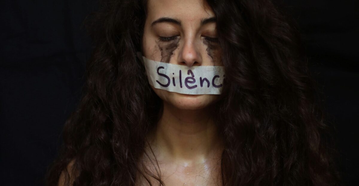 Silence symbolized by tape on a woman s mouth