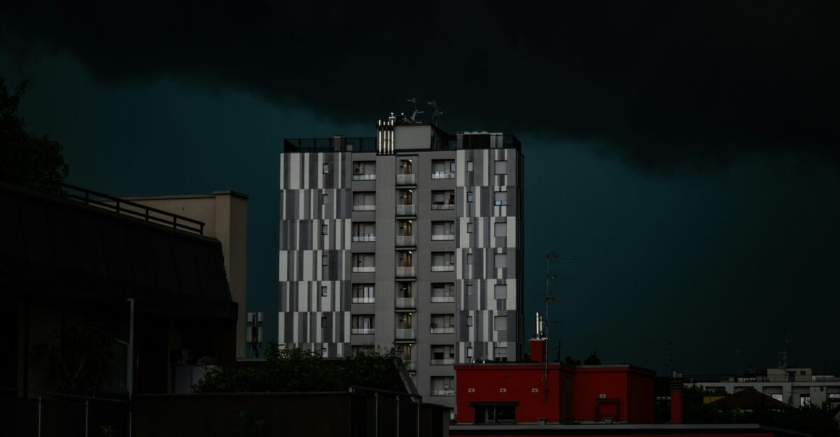 A tall building stands before a stormy sky