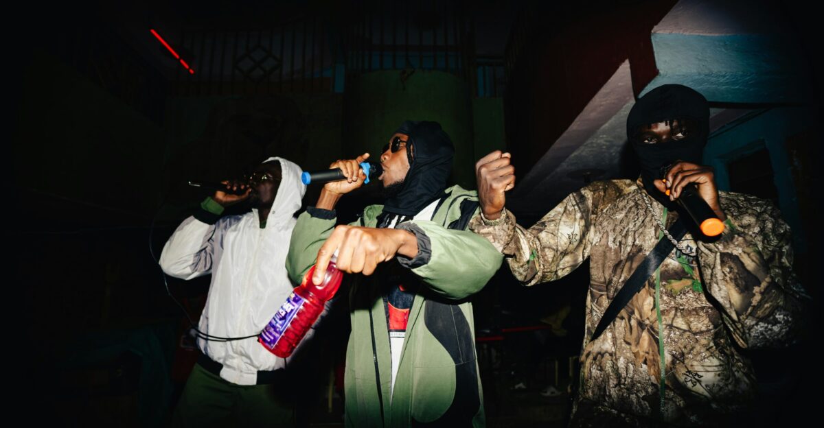 Three people rapping into microphones on stage