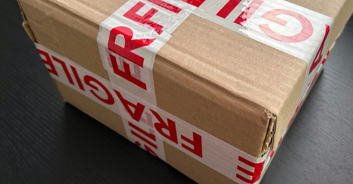 Cardboard box sealed with red fragile tape