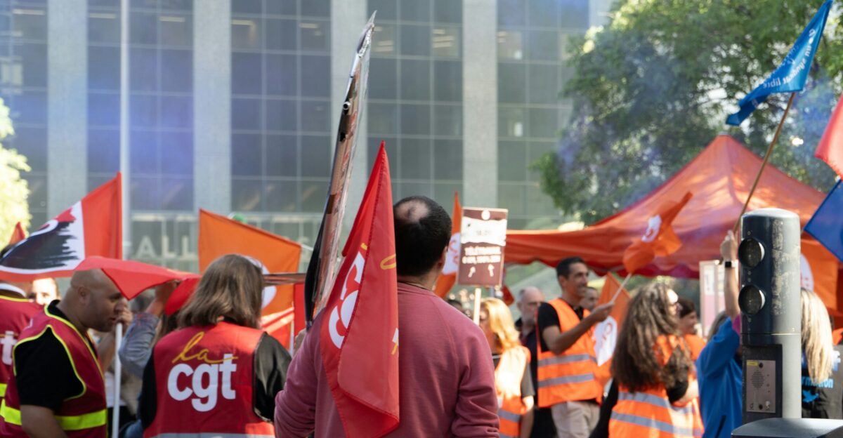 People holding flags at a rally with orange tents