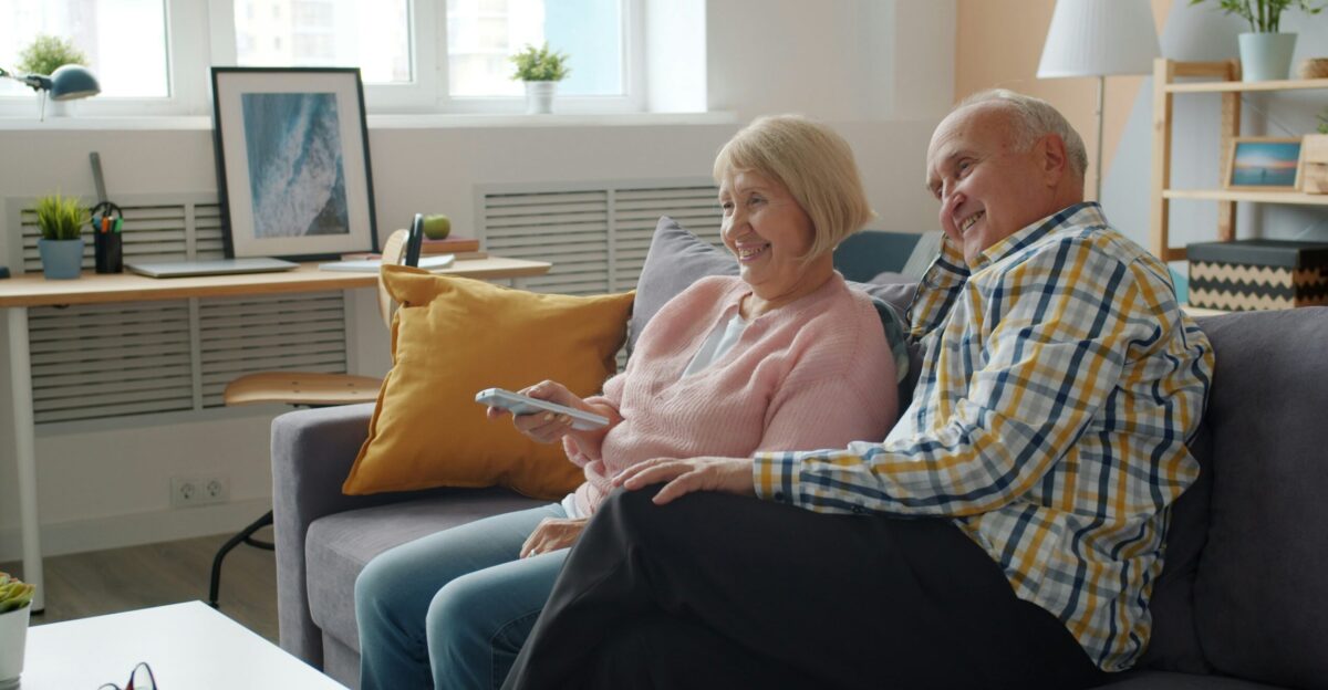 Elderly couple relaxing on a couch watching television