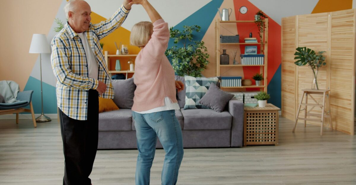 Elderly couple dancing joyfully in a living room