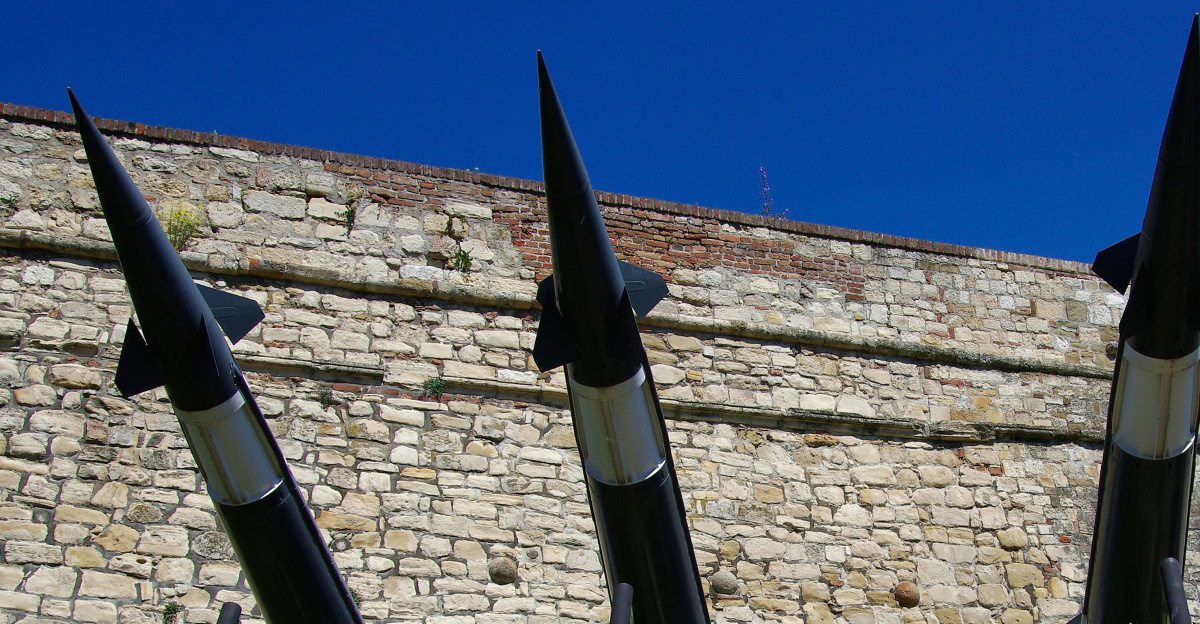 Four missiles on a launch platform with brick wall background