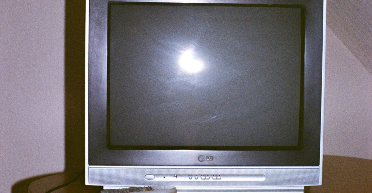 A television set with a remote control on a table