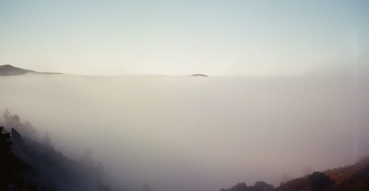 Foggy valley with distant island and hills