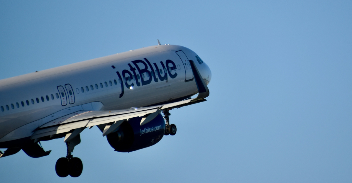 Jetblue airplane ascending into a clear blue sky