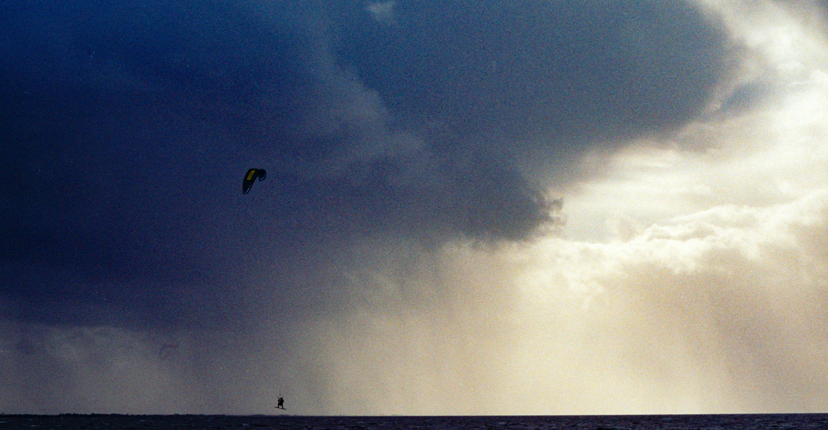 Dark storm clouds gather over a rough ocean.