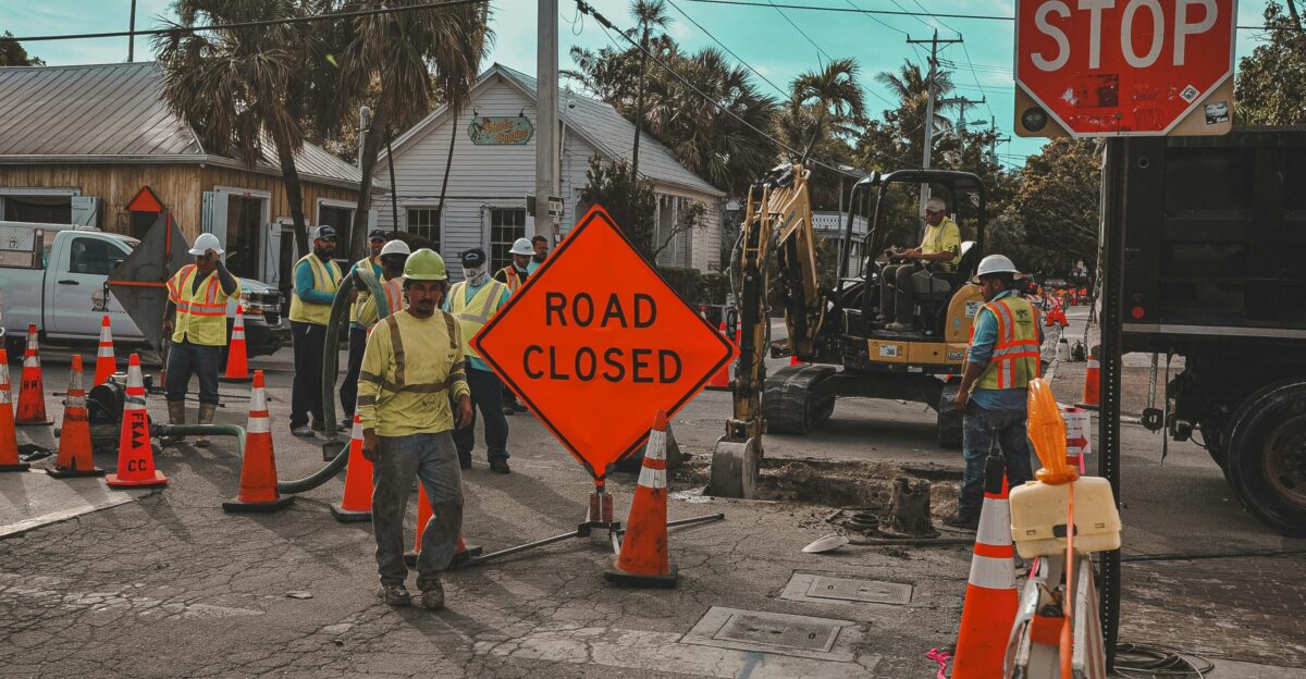 Construction workers and road closed signs on a street