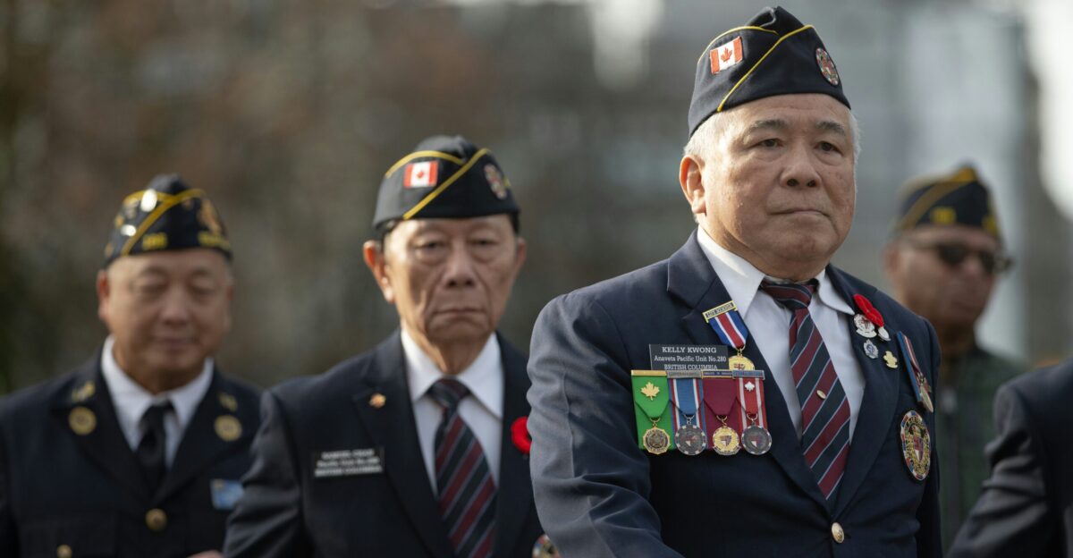 Veterans in uniform marching with medals