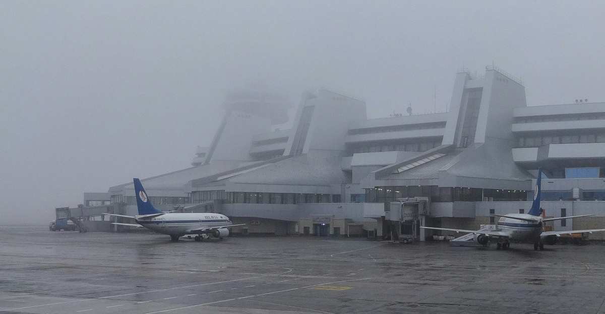 Airport terminal in foggy weather with airplanes