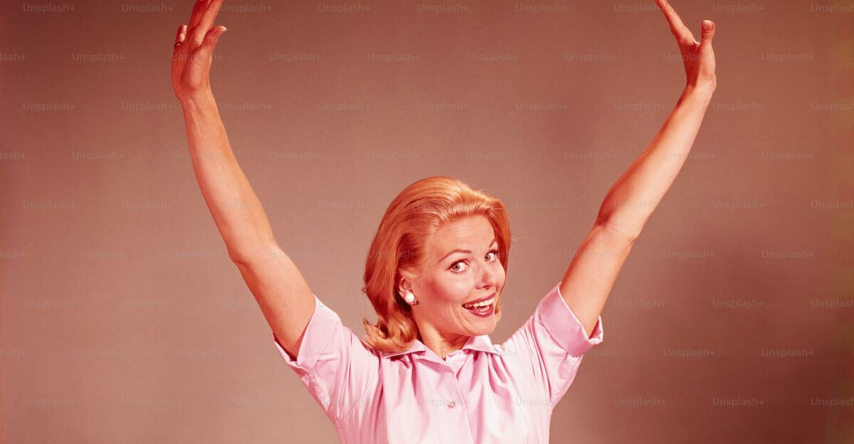 UNITED STATES - CIRCA 1960s Young woman smiling stretching arms