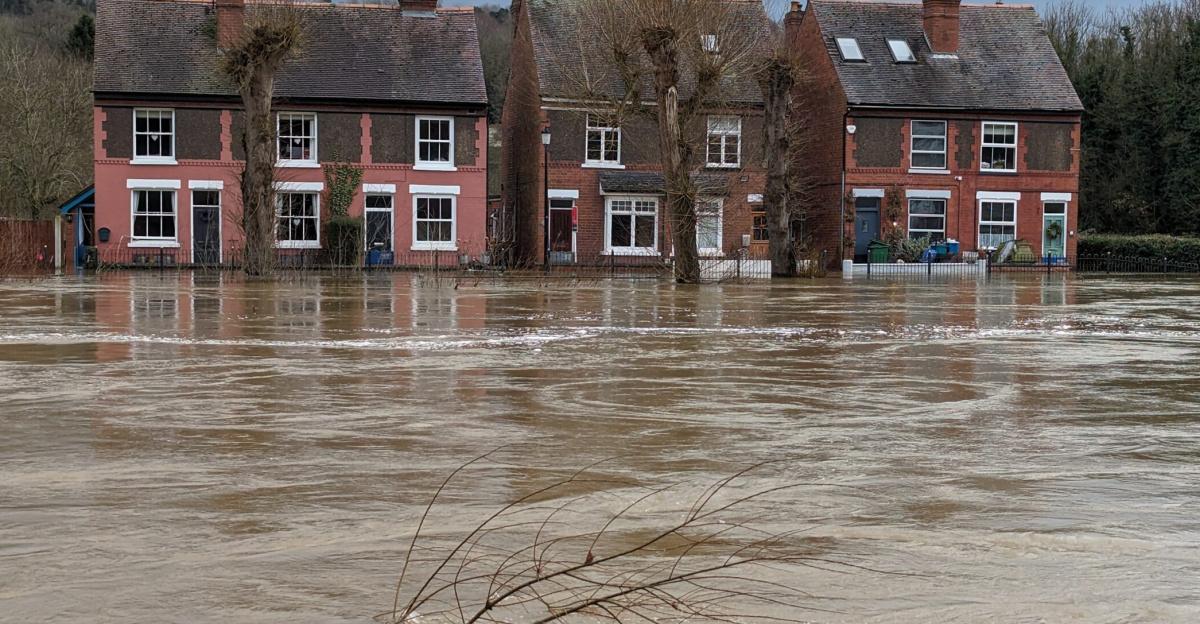 The water is right up to their front doors, which have flood gates in place to minimise the impacts of the water ingress. The River Severn is demonstrating huge power at this moment, with a very fast flow of hundreds of tonnes of water from left to right.<br>
At the time of the photo (12:15) the river level was 4.85 m, having peaked a couple of hours earlier at 4.9 m.