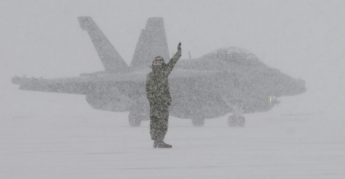 NAVAL AIR FACILITY MISAWA Japan Jan 10 2013 A ground crew member from Electronic Attack Squadron VAQ 132 signals to an EA-18G Growler as it returns from a flight during heavy snows at Naval Air Facility Misawa VAQ-132 is finishing up a six-month deployment in support of U S 7th Fleet U S Navy photo by Mass Communication Specialist 1st Class Kenneth G Takada Released 130110-N-VZ328-444 Join the conversation navylive dodlive mil