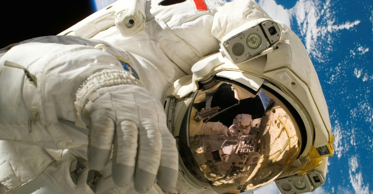 Astronaut floating in space during a spacewalk, visible Earth in the background.