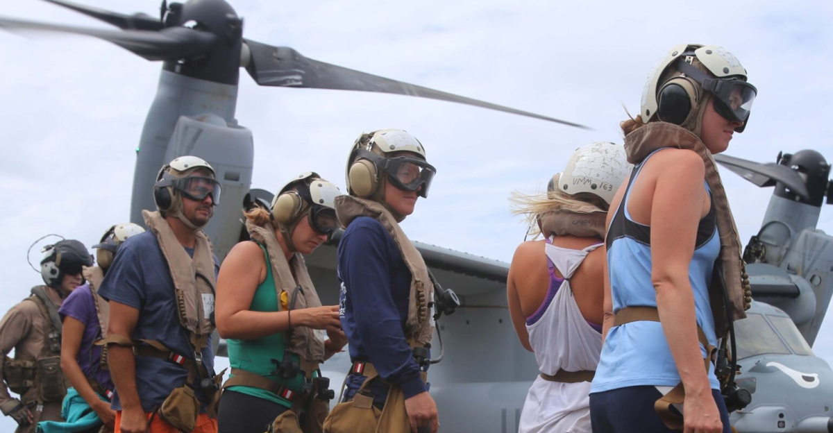 National Oceanic Atmospheric Administration (NOAA) personnel standby before being escorted onto an MV-22B Osprey en route to Midway Atoll, Hawaii as part of the MEU’s WESTPAC 14-2 deployment Aug. 8, 2014. The recovery of NOAA personnel was executed because of the threat of hurricane Iselle, the first hurricane to strike the Hawaii islands in more than two decades, which threatened the safety of the researchers. (U.S. Marine Corps photo by Cpl. Demetrius Morgan/RELEASED)