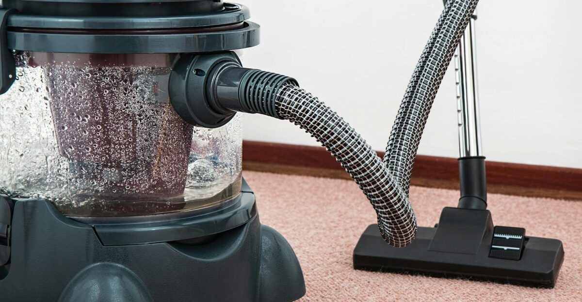 Close-up of a modern vacuum cleaner with water filtration on carpet floor indoors