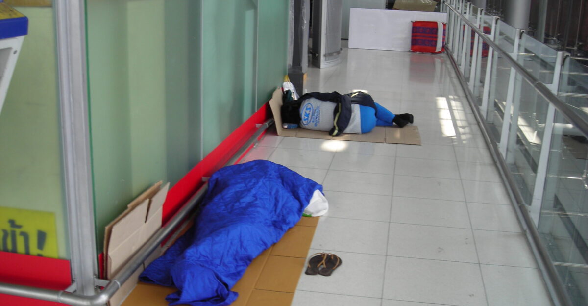 Workers taking a nap in the Suvarnabhumi International Airport Passenger terminal 4th floor behind the Post office Sleeping bags are used because of the cold air which results from the air conditioners