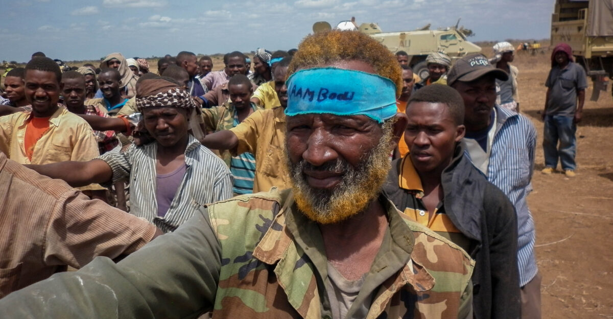 Members of the Al Qaeda-affiliated militant group Al Shabaab stand after giving themselves up to forces of the African Union Mission in Somalia AMISOM in Garsale approximately 10km from the town of Jowhar 80km north of the capital Mogadishu 22 September 2012 Over 200 militants disengaged following in-fighting between militants in the region in which 8 Al Shabaab were killed including 2 senior commanders The former fighters were peacefully taken into AMISOM s protection handing in over 80 weapons in the process in a further indication that the once-feared militant group is now divided and being defeated across Somalia Deputy Force Commander of AMISOM Operations Brigadier Michael Ondoga said a number of militants have contacted the AU force indicating their wish to cease fighting and that they their safety is assured if they give themselves up peacefully to AMISOM forces AU-UN IST PHOTO ABUKAR ALBADRI