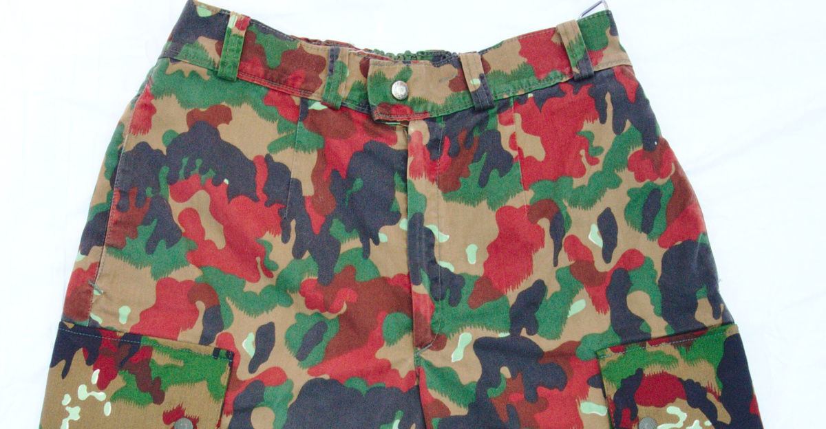 A pair of men's cargo shorts, with a camouflage pattern in black, red, green and khaki