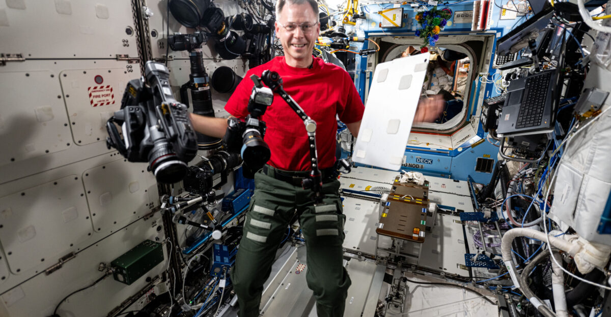 iss072e391353 Dec 17 2024 - NASA astronaut and Expedition 72 Flight Engineer Nick Hague demonstrates the range of motion and stability of student-designed space hardware aboard the International Space Station s Destiny laboratory module Hague was testing the HUNCH High school students United with NASA to Create Hardware Utility Bracket for its ability to hold and position cameras computer tablets and other tools astronauts use daily
