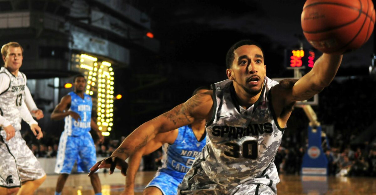 Intense basketball game with athletes in action on an outdoor court during nighttime
