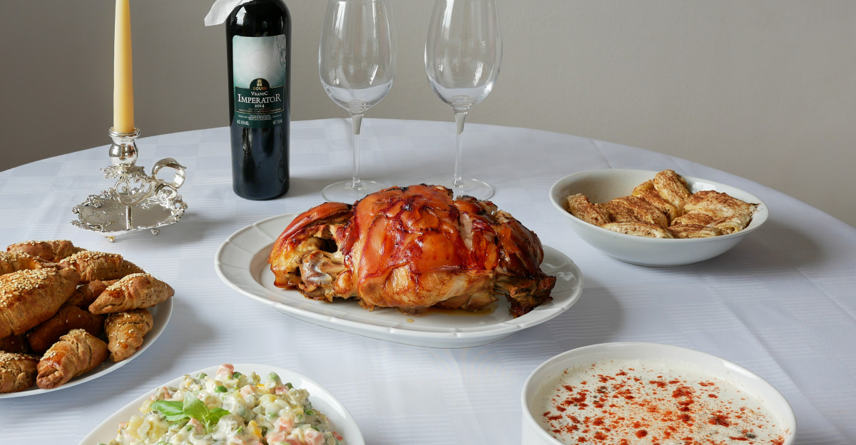 Christmas table Cuisine of Serbia grilled pork Olivier salad also called Russian salad tzatziki salad red wine Vranac kifli and strudel sweets