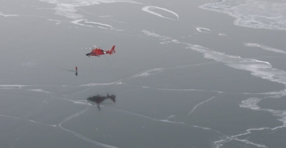 A Coast Guard Dolphin helicopter from Air Station Detroit hovers above ice-covered Lake Erie while a crew member works to gather ice depth measurements in support of the National Oceanic and Atmospheric Administration, March 5, 2014. During the two-day mission, measurements were taken in 20 locations around the lake with depth readings ranging from 3 inches to more than 3 feet.