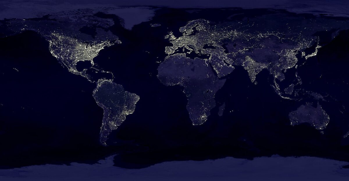 Satellite view of Earth at night with illuminated cities across continents