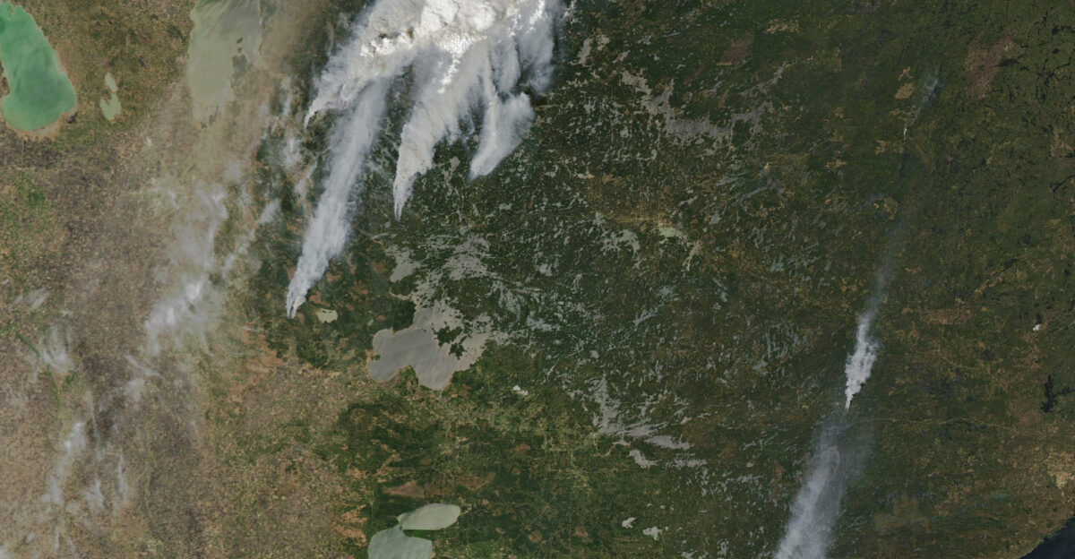 Wildland fires broke out in forests along the Manitoba-Ontario border in Canada and in northern Minnesota in the United States in May 2025 Several blazes grew rapidly in size amid hot dry and windy conditions in the region Smoke from multiple fires drifted hundreds of kilometers across northern forests on the afternoon of May 13 when the MODIS Moderate Resolution Imaging Spectroradiometer on NASA s Aqua satellite captured this image Some of the largest fires seen here started the previous day and had expanded rapidly by the time this image was acquired For comparison the right image shows the same area in false color MODIS bands 7-2-1 to help distinguish smoke cyan blue from clouds white Bright red-orange indicates visible fire fronts Large smoke plumes billowed from blazes near Lac du Bonnet in eastern Manitoba One fire close to the rural municipality burned thousands of hectares and threatened infrastructure Another one to the northeast near Nopiming Provincial Park exhibited extremely volatile fire behavior on May 13 officials said and grew to 100 000 hectares 250 000 acres Authorities closed multiple provincial parks due to the fires and issued evacuation orders for several communities in both Manitoba and Ontario In the U S multiple fires broke out in northern Minnesota on May 11 and 12 The two largest Camp House and Jenkins Creek had burned a combined 7 600 hectares 18 800 acres about 65 kilometers 40 miles north of Duluth as of May 13 In and around the town of Brimson they destroyed more than 100 structures and damaged bridges and roadways according to news reports Unseasonably hot and dry conditions elevated fire risk in the region Winnipeg Manitoba reached 35 2 degrees Celsius 95 4 degrees Fahrenheit on May 12 topping the previous daily high temperature record set in 1958 Duluth Minnesota saw a high temperature of 30 C 86 F that day also a new record Eighty of Minnesota s 87 counties were under a Red Flag Warning due to the extreme fire danger on May 12 April and May are typically busy months for wildland fires in the state said Patty Thielen forestry director for the Minnesota Department of Natural Resources in a briefing However she noted the area already burned statewide in 2025 is roughly triple the amount burned in an average year NASA Earth Observatory image by Michala Garrison using MODIS data from NASA EOSDIS LANCE and GIBS Worldview Story by Lindsey Doermann