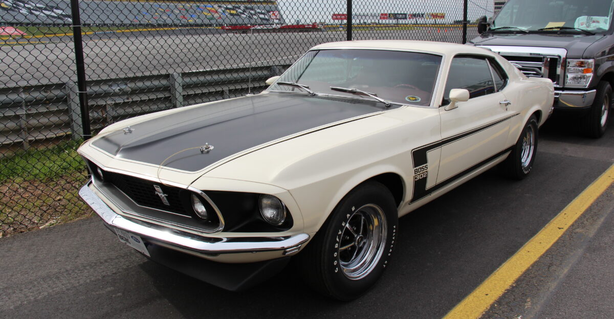 Wimbledon White The 1969 Mustang got a new body nearly 4 inches longer than the 1968 model The Fastback was now called the Sportsroof This model the Boss 302 was built for Trans Am homologation to race against the likes of the Cuda AAR TA Challenger and Z28 Camaro The car featured reflective c-stripe front and rear spoilers and the fake rear fender scoops of the regular 1969 Mustangs were eliminated The engine in the Boss 302 was rated at 290bhp conservative G code 351 Cleveland heads on a Tunnel Port 302 Windsor Block 1628 1969 Boss 302s made It also got disc brakes and a larger sway bar Other Sportsroofs available were Boss 429 for NASCAR homologation and Mach I in 351 or 428 Cobra Jet Hardtops and Convertibles also available in base models Photographed at the 50th Anniversary of the Mustang celebrations at the Charlotte Motor Speedway April 2014