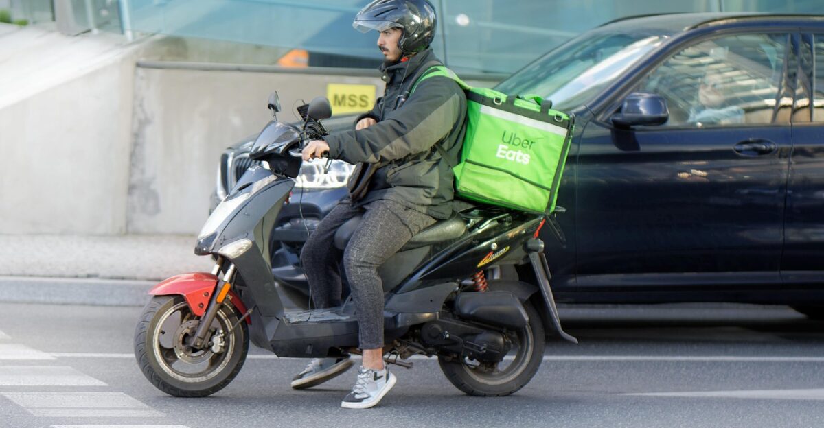 food delivery courier motorcycle waiting traffic transport delivery street road city urban man job helmet box snapshot street photography