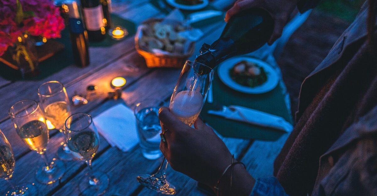 celebration champagne glasses pour pouring champagne glasses bottle champagne bottle glassware stemware dark dinner evening light party person table drinks cheers champagne dinner dinner party party party party party