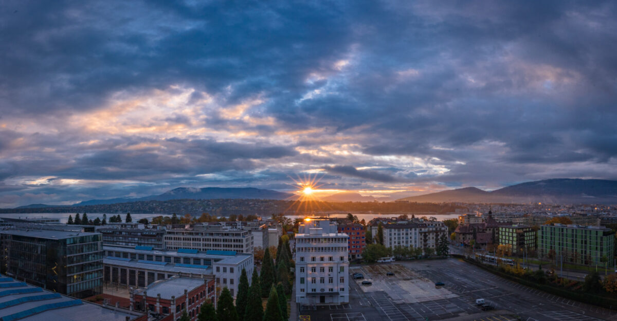 The Autumn in Geneva tends to be rainy and cloudy I was standing on the top floor of the Picciotto Student House overlooking the Lake Geneva lac L man in French and the city When the sun rises from behind Mont Blanc and sheds light across the thick cloud the Sunstar effect is really impressive and the whole city glimmers in golden gentleness