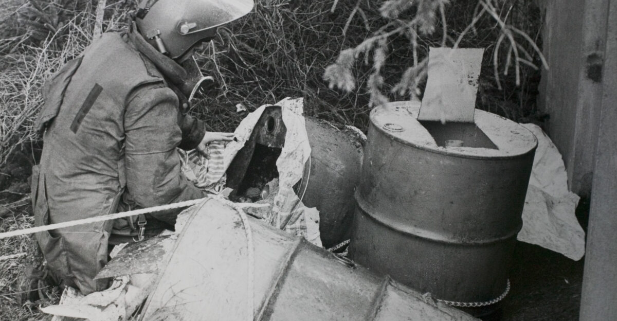 Pictured are Home-made explosives packed in oil drums after having been dragged out of a culvert under a road intended to kill a security force drive by patrol being dealt with by the number one EOD operator in 1984 Organization Army Object Name g065d052 Category MOD Supplemental Categories People Army Operations Counter IED Equipment Keywords Army Equipment Clothing Personnel Non-Identifiable Soldier Male Man CIED Counter IED Improvised Explosive Device Historic EOD Crouching Black and White 321 EOD Northern Ireland HQNI RLC Royal Logistic Corps Oil Drum Country Northern Ireland