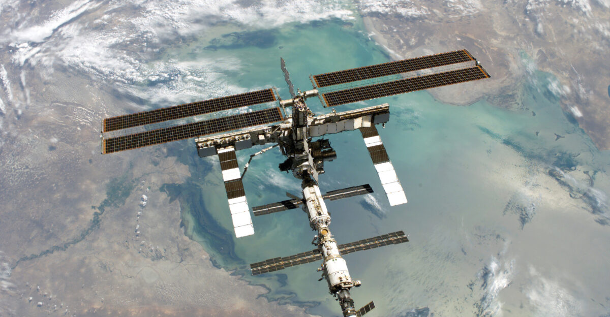 ISS photo taken from shuttle Discovery in August 2005 Original description Backdropped by a colorful Earth this full view of the International Space Station was photographed from the Space Shuttle Discovery during the STS-114 Return to Flight mission following the undocking of the two spacecraft The upper part of the Caspian Sea is visible in the background the Volga delta is the dark area in the lower right Editing Brightness and contrast was enhanced saved 85 JPEG