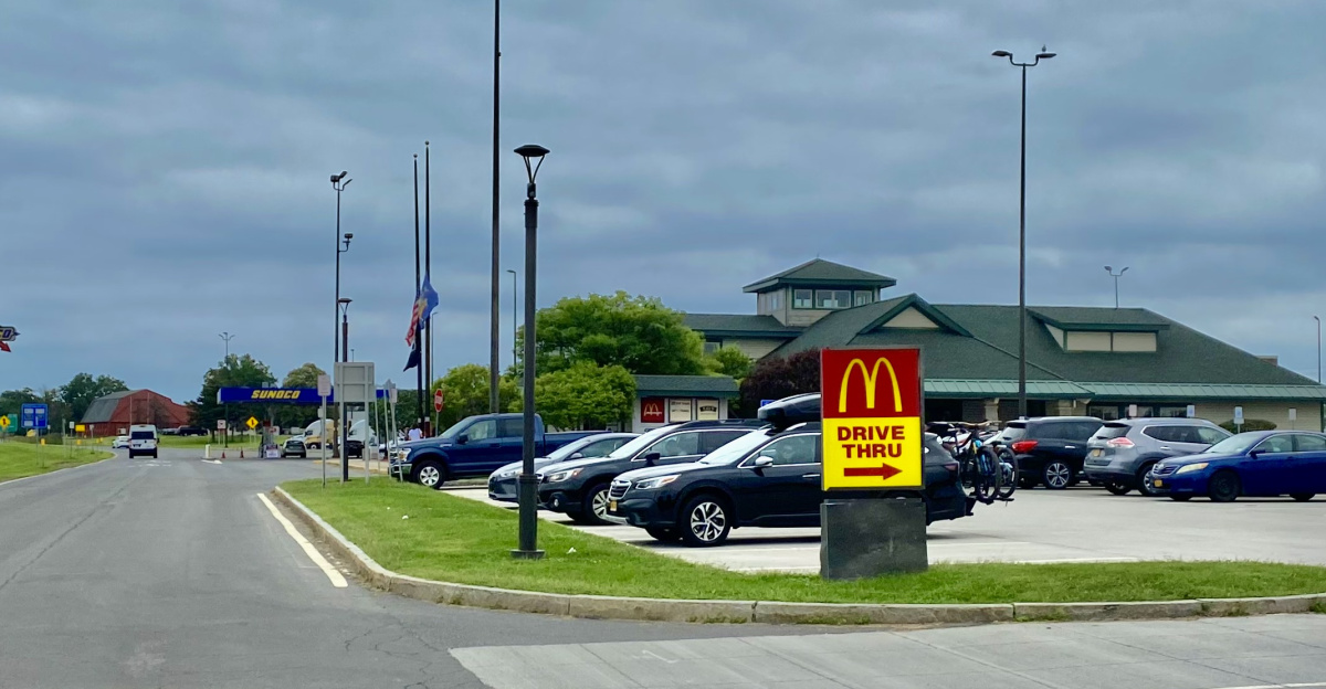 At the New York State Thruway's DeWitt Service Area, the passenger-car entrance to the parking lot doubles as the beginning of the drive-thru line for the in-house McDonald's outlet. As seen in August 2021.
