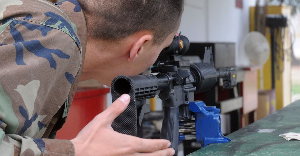 Petty Officer 3rd Class Mark Sorokey, a gunner's mate assigned to Naval Mobile Construction Battalion 74, Headquarters Company, calibrates an Advanced Combat Optical Gunsight to battle site zero using a laser bore light. NMCB 74 is currently deployed to Camp Mitchell on board Naval Station Rota, Spain, supporting Combined Joint Taskforce SIXTY-EIGHT.