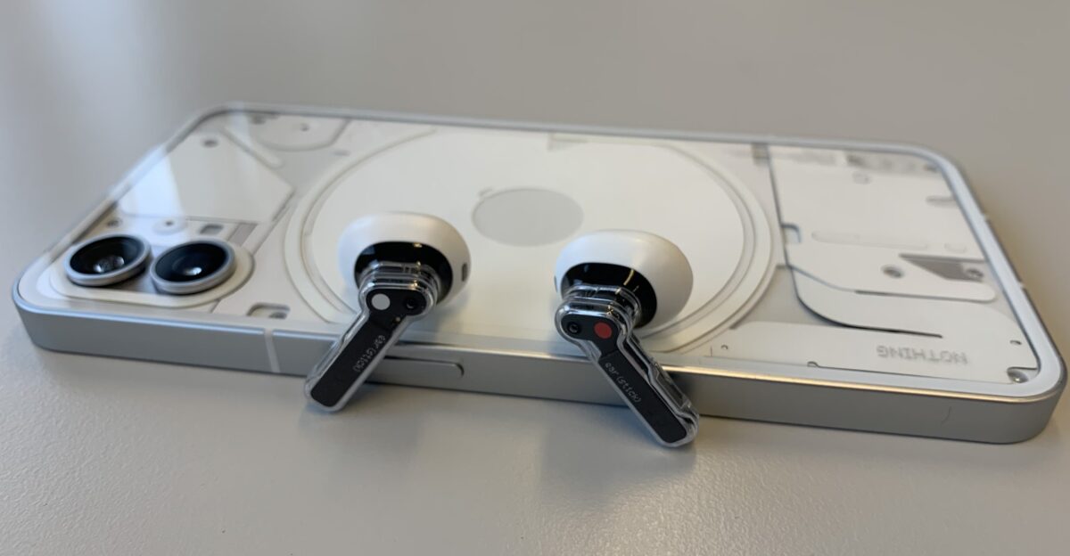 Nothing Phone 1 and ear stick buds on top of the phone