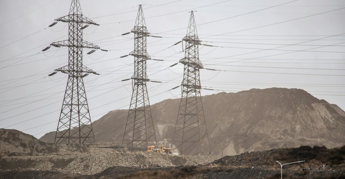 High voltage power lines and steel towers stretch across an industrial landscape in Zaporizhzhia Ukraine