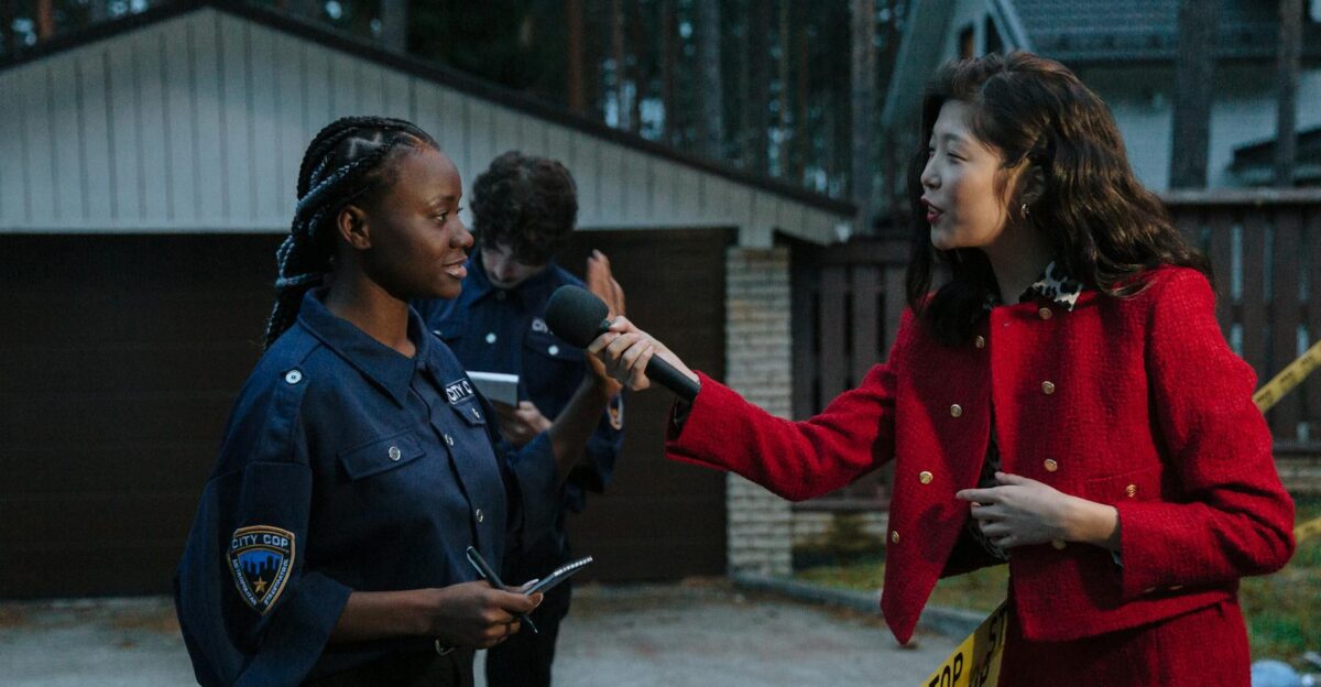 A journalist interviewing a policewoman at a crime scene during twilight