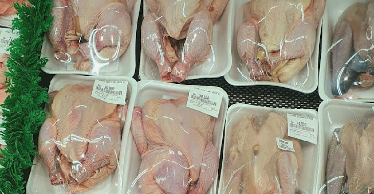 Plastic-wrapped raw chickens neatly arranged on supermarket shelves ready for purchase