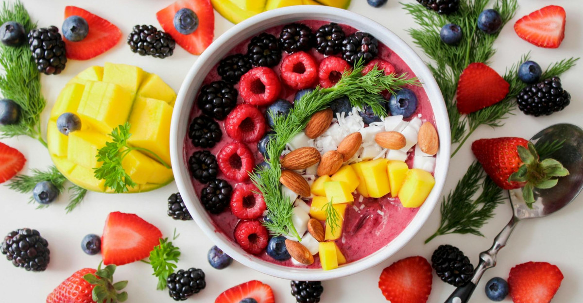 A vibrant healthy fruit smoothie bowl topped with fresh berries mango and almonds