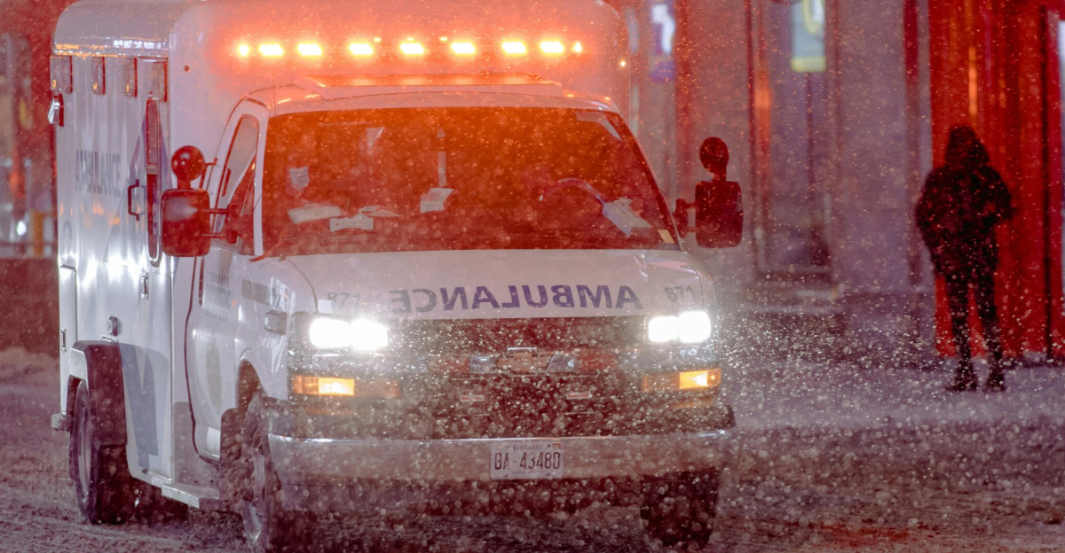 Ambulance on a snowy street during a winter emergency response at night.