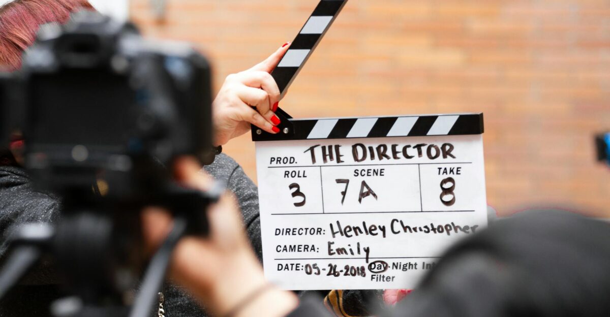 Close-up of film clapperboard in action with camera filming a take on set