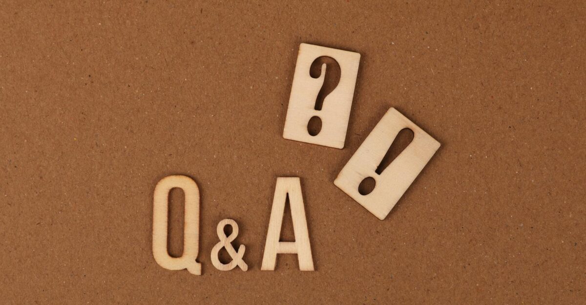 Wooden cutouts of Q A with question and exclamation marks on a brown backdrop