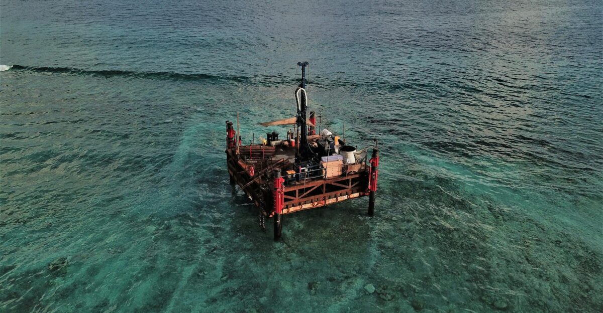 Aerial high-angle shot of an offshore platform in the clear waters of the Maldives
