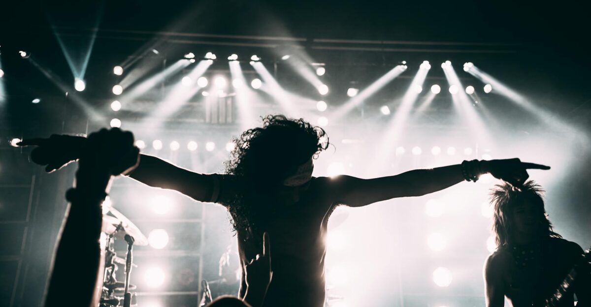 Energetic rock band performance with striking stage lights and silhouettes