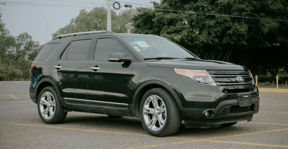 A black SUV parked outdoors in a spacious and empty parking area